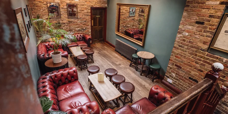 The downstairs room with chesterfield sofas and exposed brick